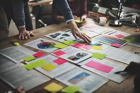 Desk full of papers and sticky notes with ideas