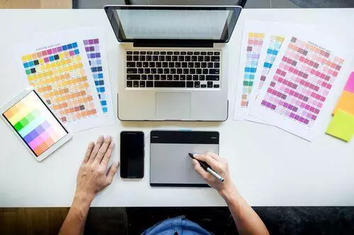 Designer picking colors from color palettes for website design